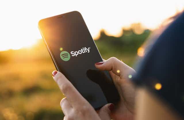 A woman using the Spotify app on a mobile phone