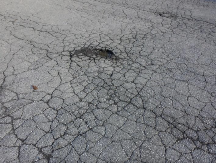 A road with a web of cracks in it.