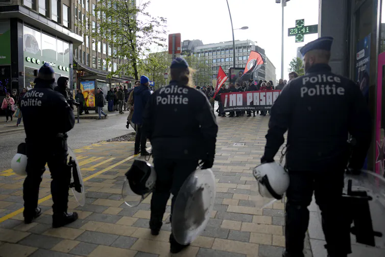 Police officers look towards a crowd of protesters.