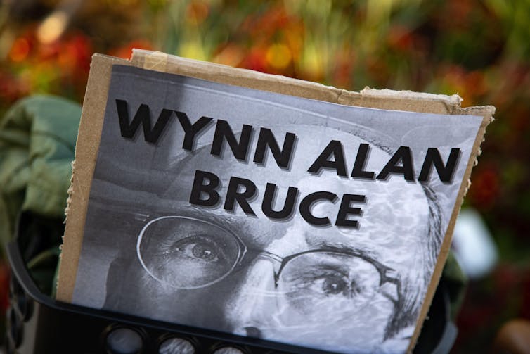 A sign with a picture of a man wearing glasses with the words.