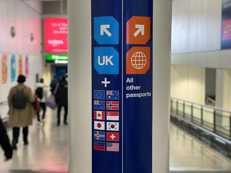 An airport sign directing UK, EU, Australia and some other passport holders to one side, all other passports to the other