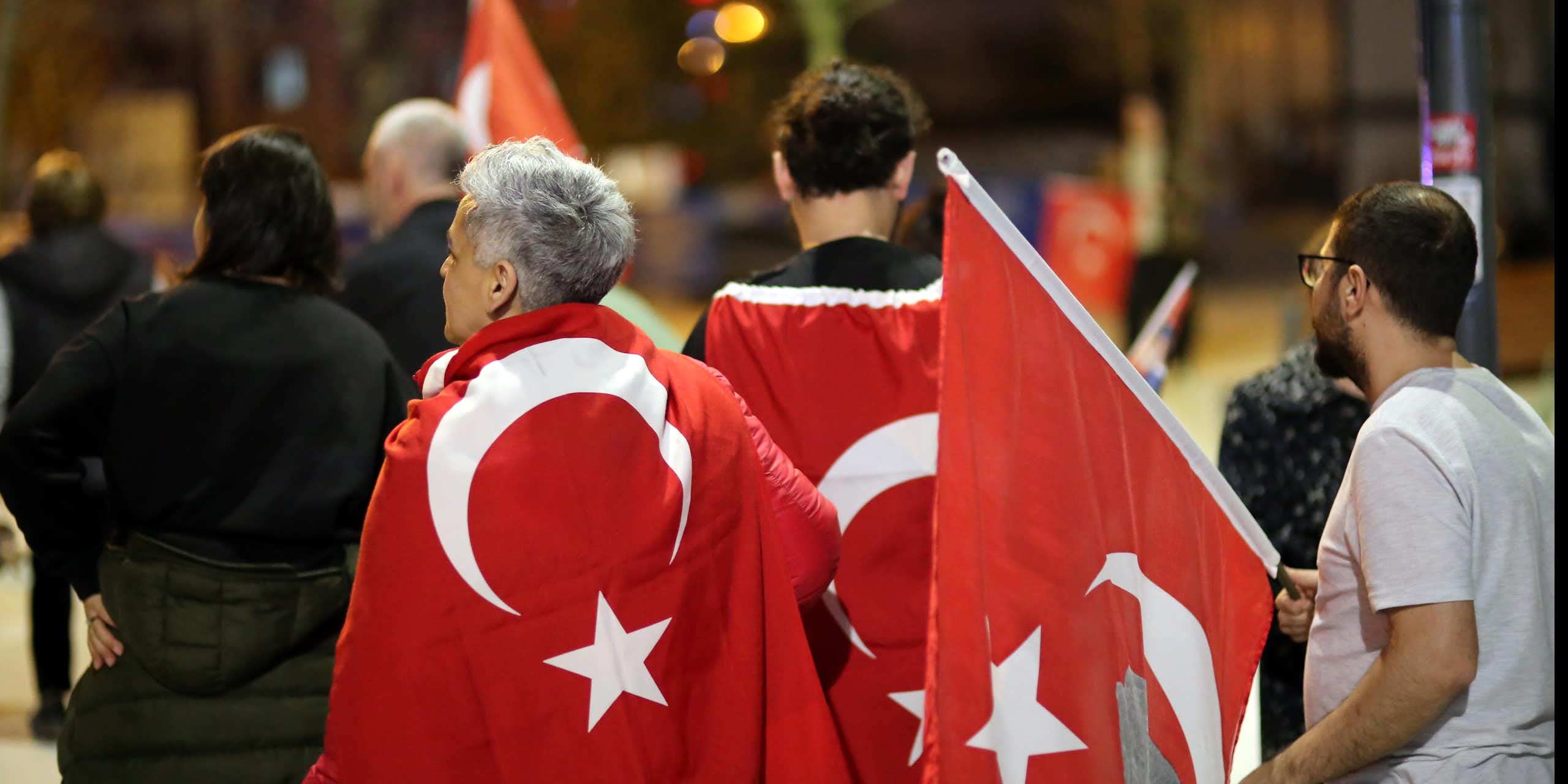 Turkish citizens waving Turkish flags and celebrating the results of the 2024 elections. 