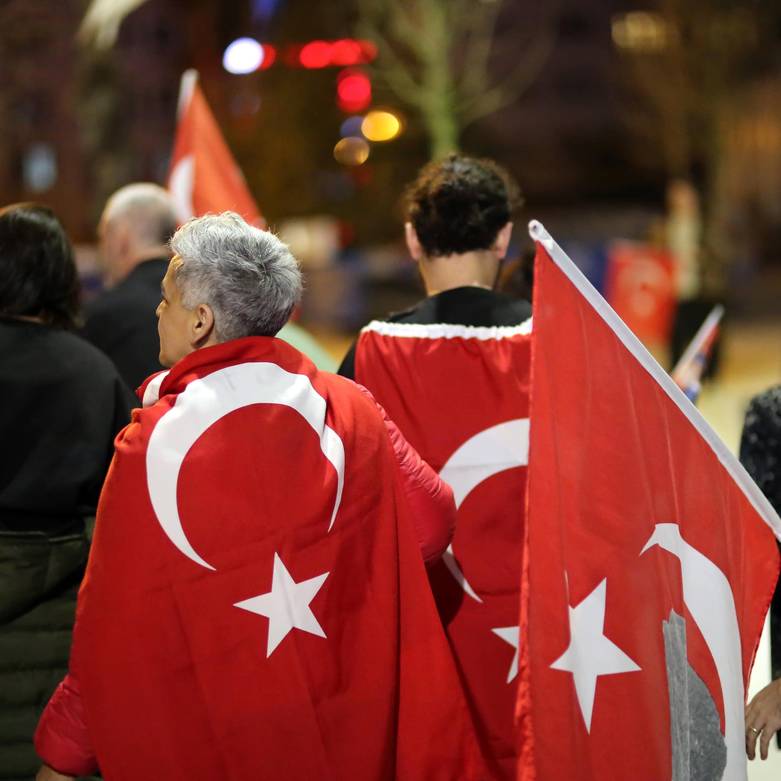 Turkish citizens waving Turkish flags and celebrating the results of the 2024 elections. 