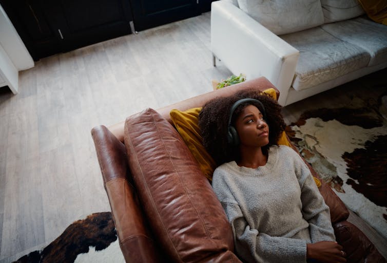 Young black woman looking sad while listening to music