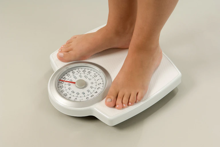 A person standing on bathroom scales