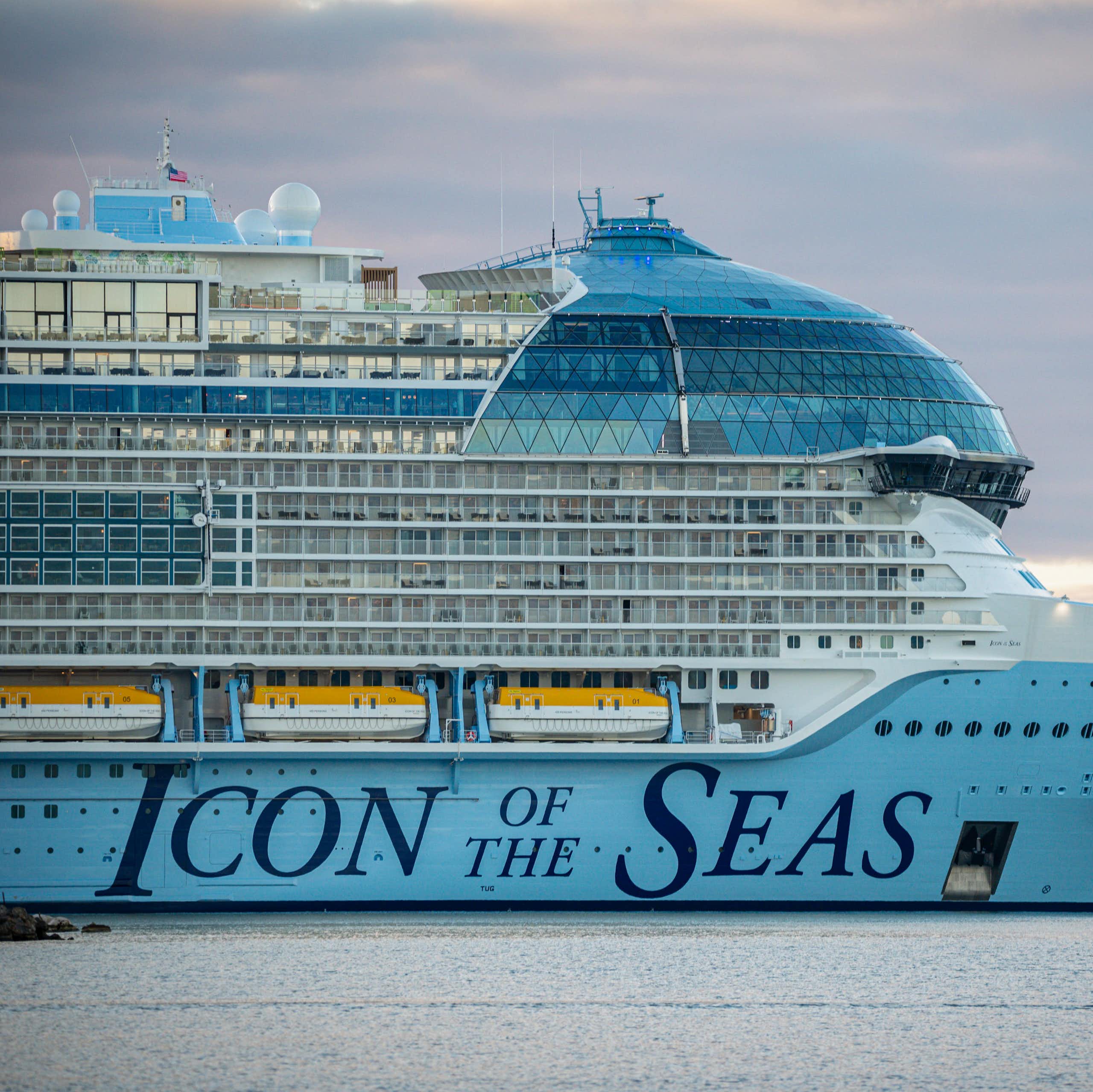 A huge cruise ship docked in the ocean with the words 'Icon of the Seas' written on the side