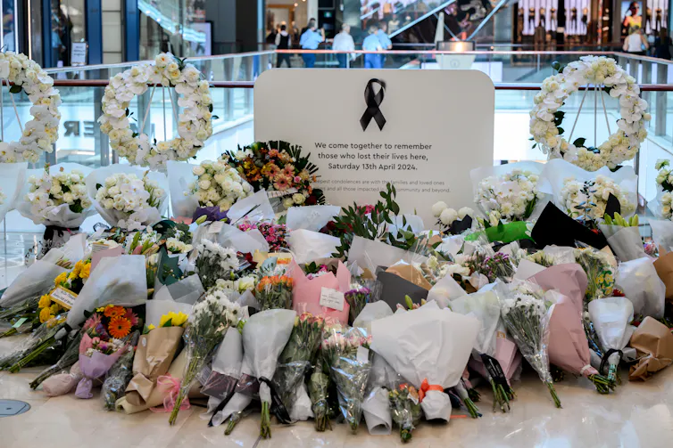 Mourners have placed flowers at the memorial site during the reopening of the Westfield Bondi Junction shopping centre in Bondi, Sydney.