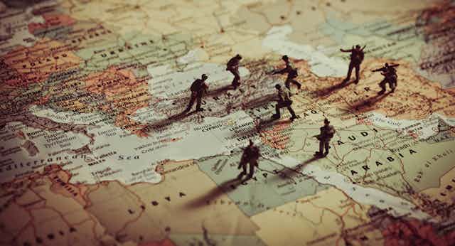 Toy soldiers positioned over the top of a map of Europe and the Middle East.