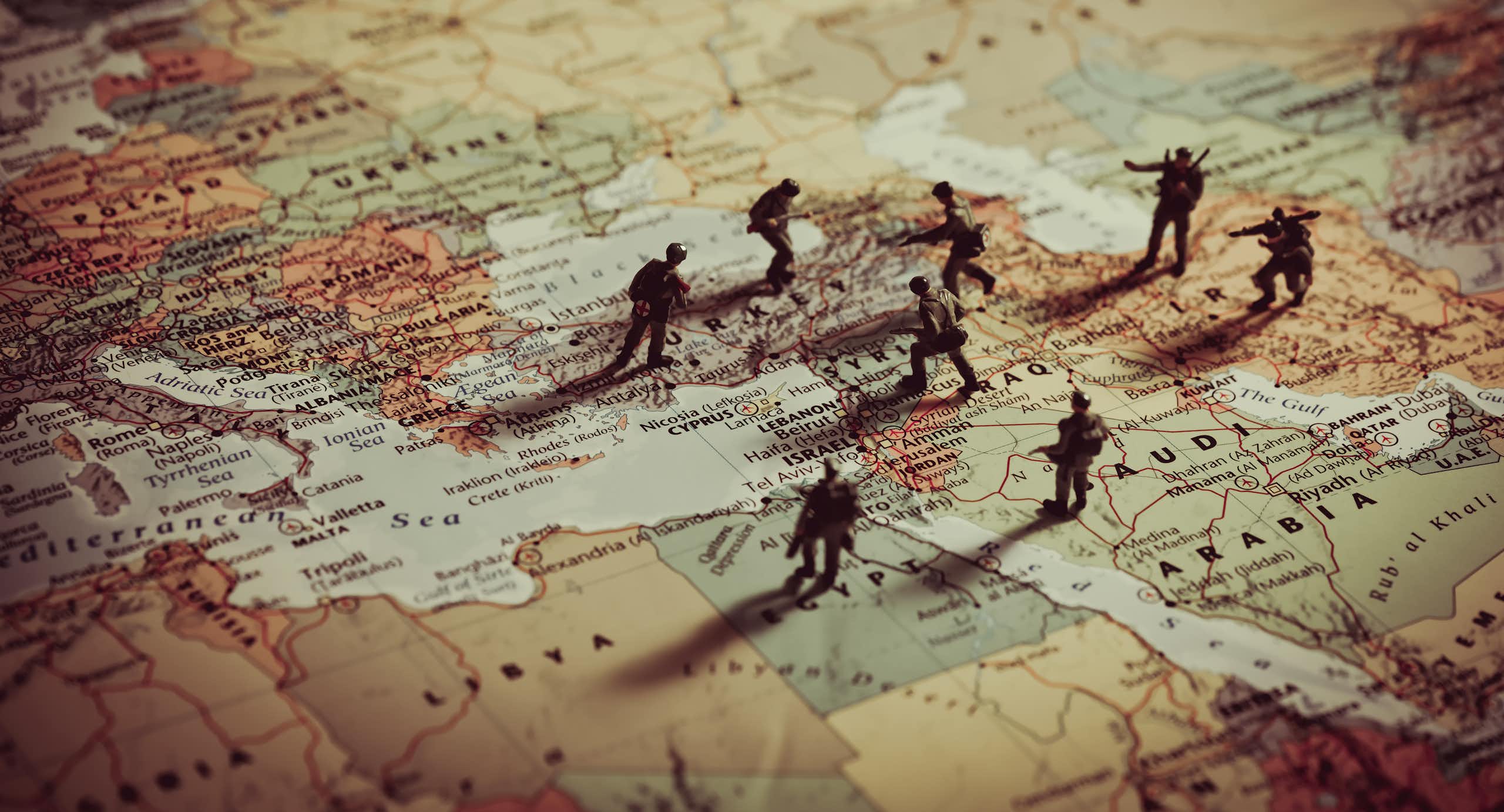 Toy soldiers positioned over the top of a map of Europe and the Middle East.