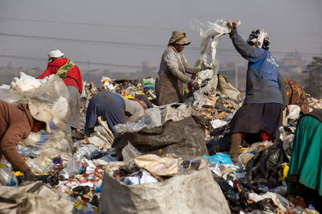 People picking waste from a refuse dump