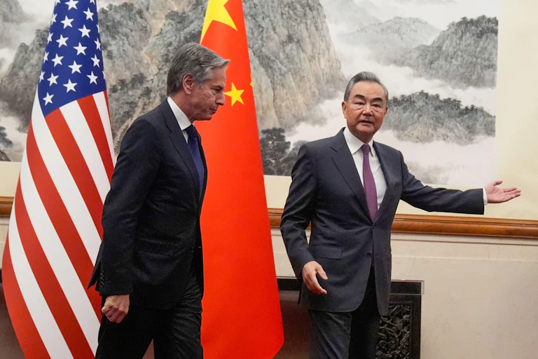 US secretary of state Antony Blinken and China's Foreign Minister Wang Yi in front of flags in Beijing on April 26.