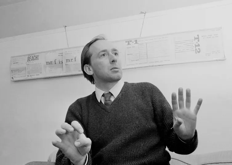 Black and white image of a man gesturing with his hands.