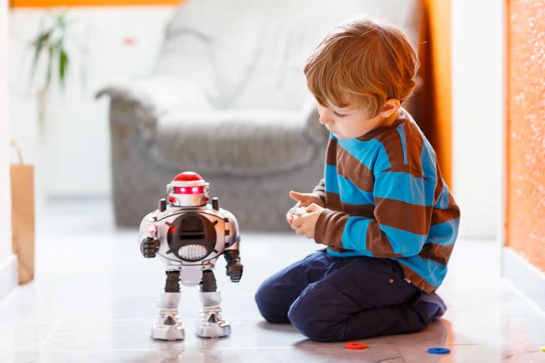 A child sitting on the floor with a robot toy.