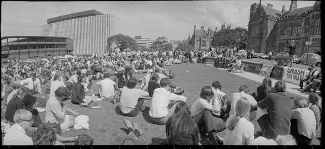 Students sitting on the lawn.