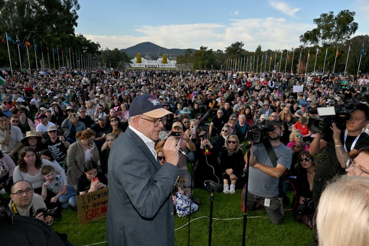 The prime minister stands in front of a crowd.