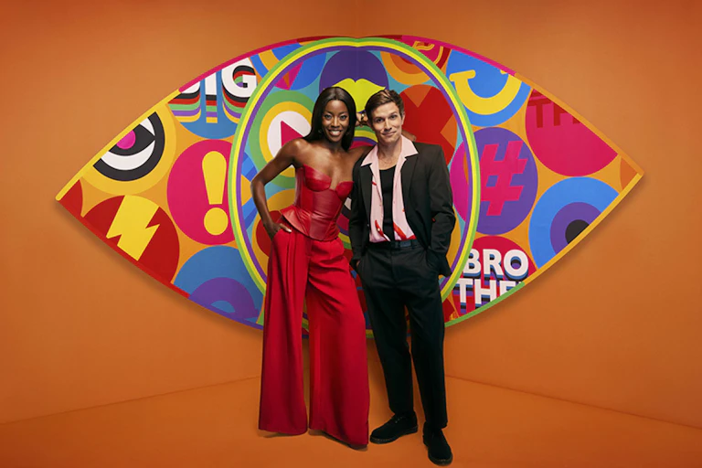 AJ Odudu and Will Best stand in front of a large colourful eye.