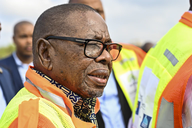 A man wearing a yellow and orange high visibility jacket over a patterned shirt