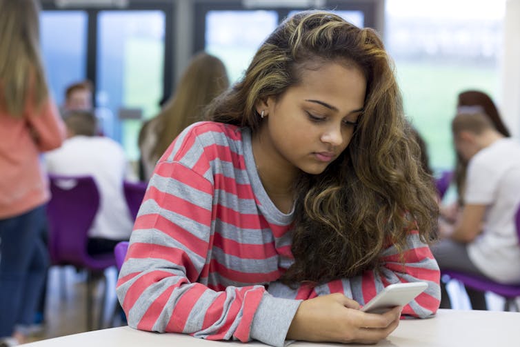 Girl at school looking at smartphone