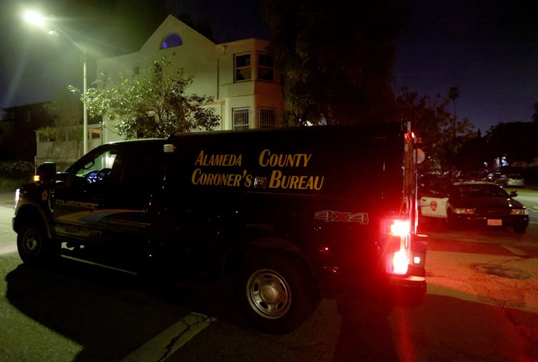 A van from a coroner's office is seen leaving the scene of a fatal shooting.