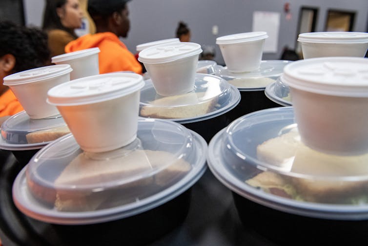 Boxed lunches on a table with people in the background