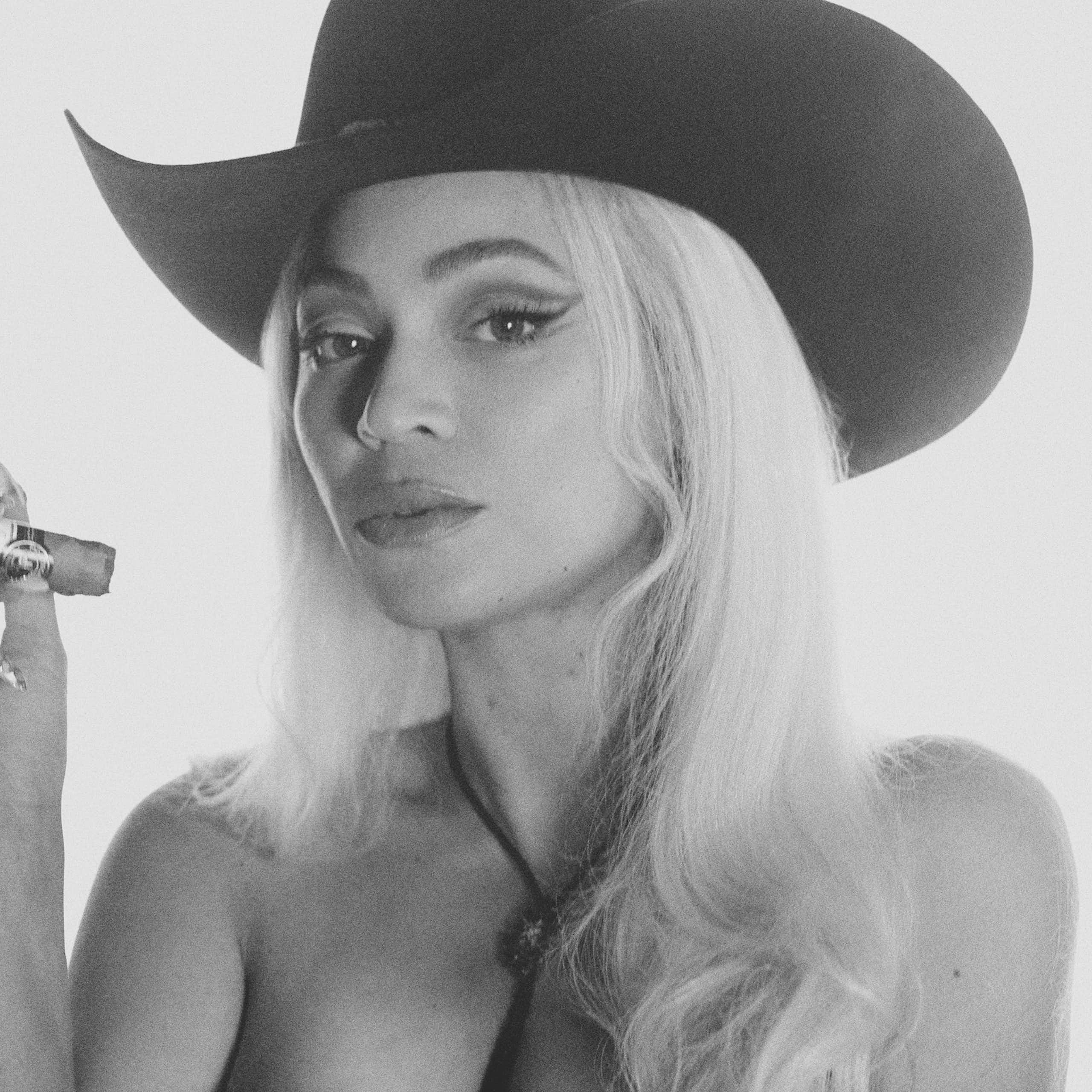 Beyonce in a stetson smoking a cigar.
