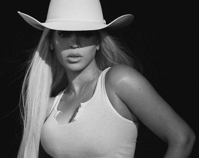 Beyonce wearing a white vest and a white stetson