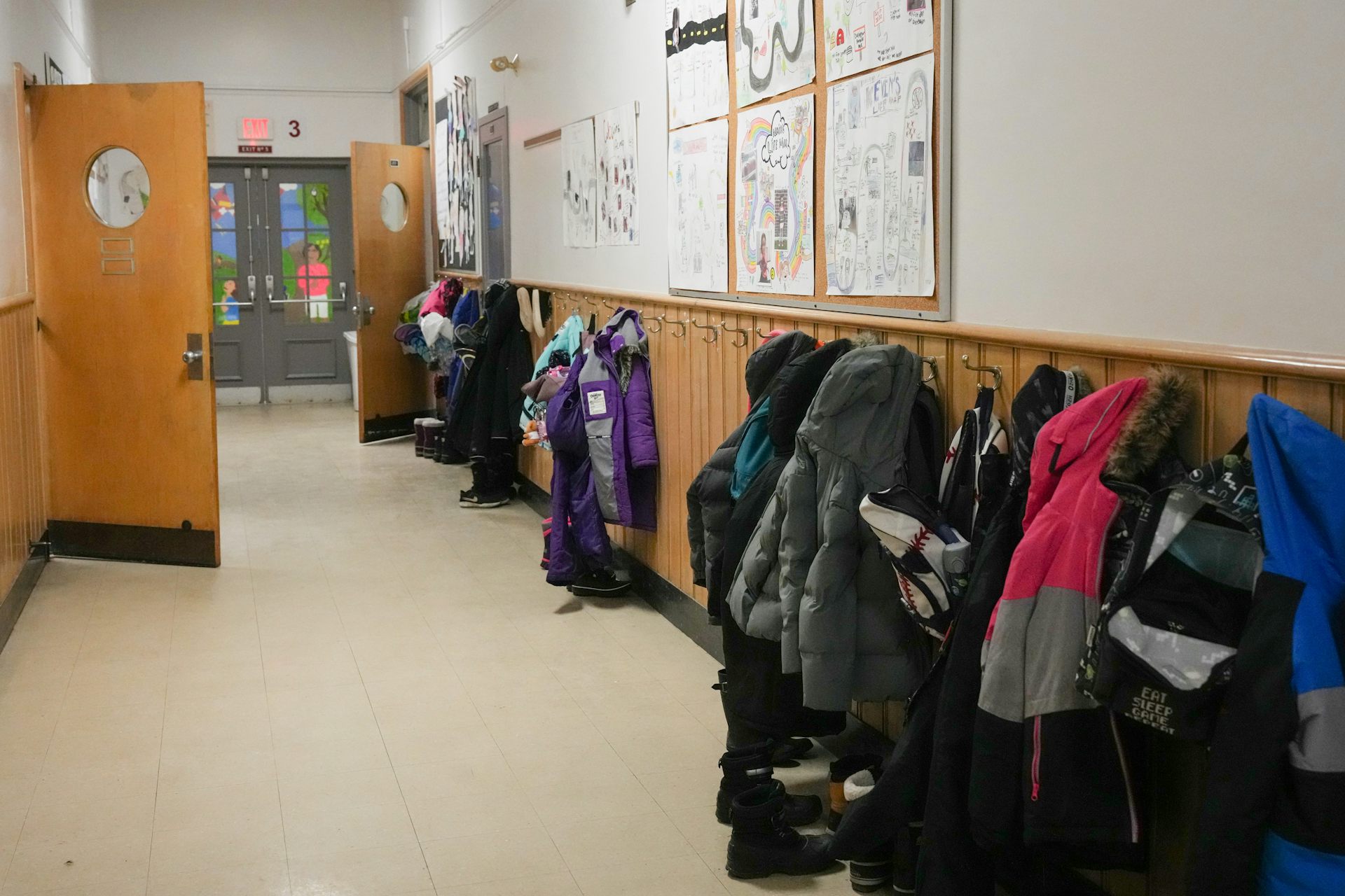 Coats seen hanging in a hallway.