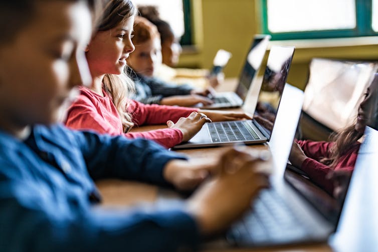 School pupils on laptops in classroom