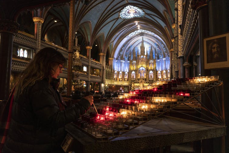 A woman lights candles in a church
