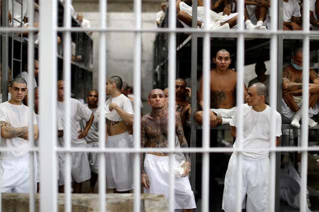 A group of heavily tattooed gang members in their prison cell.