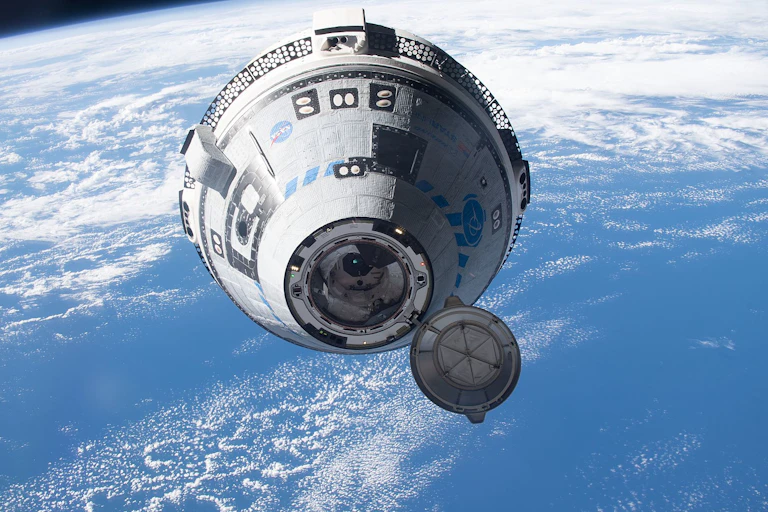 A conical capsule flies through space, with the Earth visible behind it.