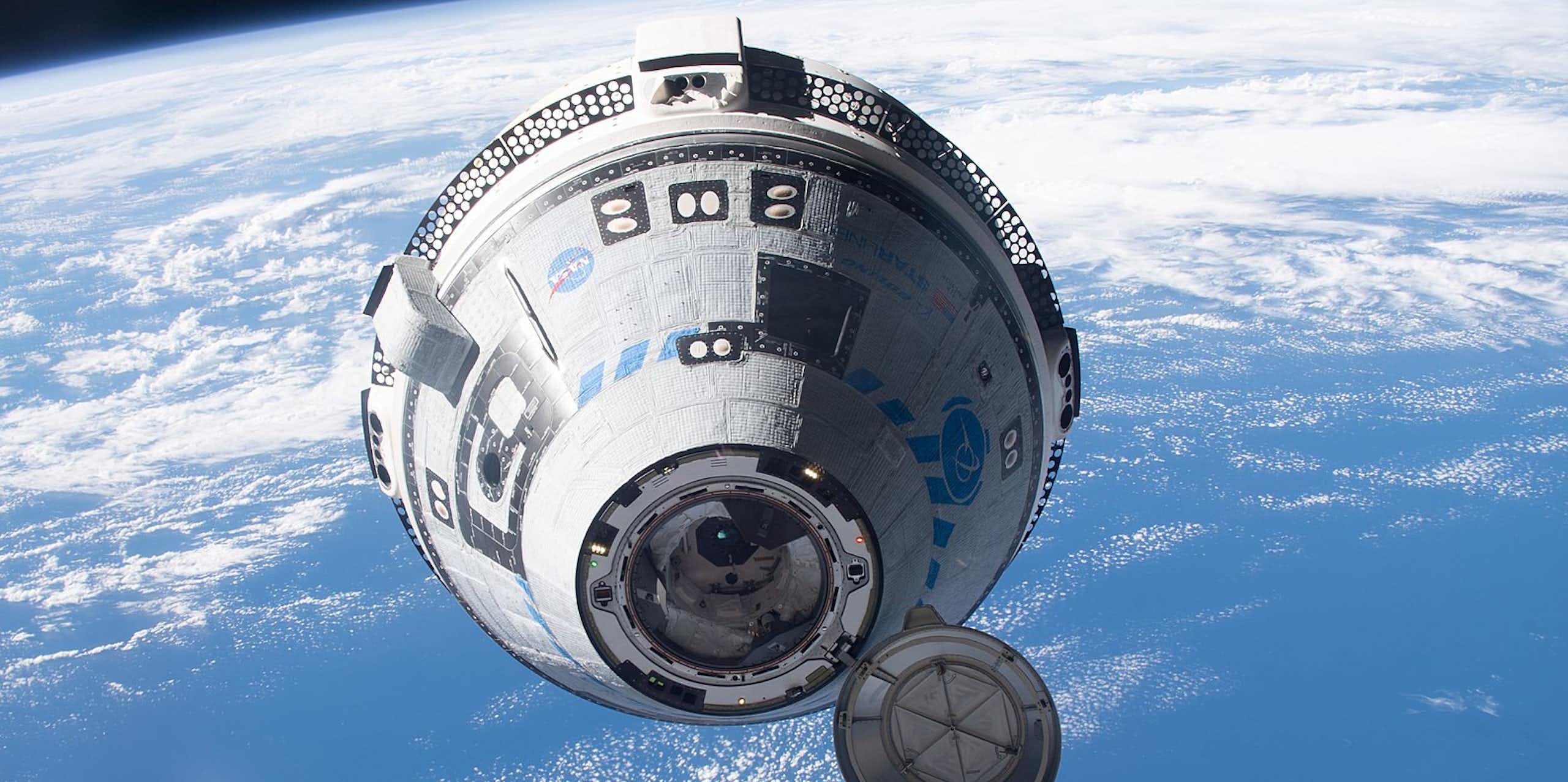 A conical capsule flies through space, with the Earth visible behind it. 