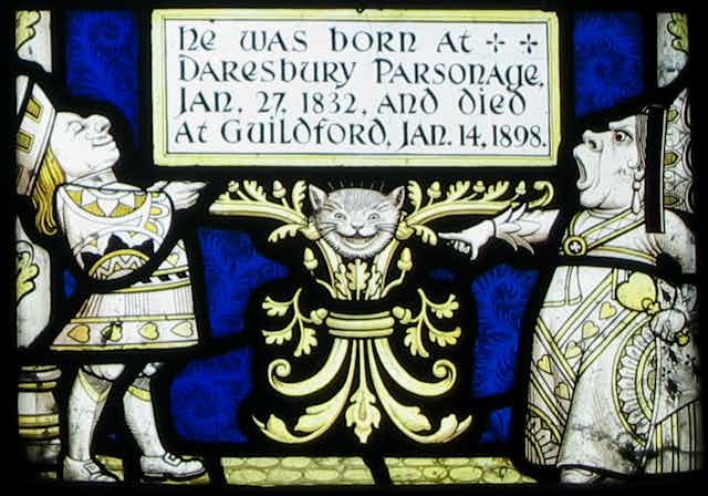 Yellow and white figures of a man and woman in fancy robes and a grinning cat's head.