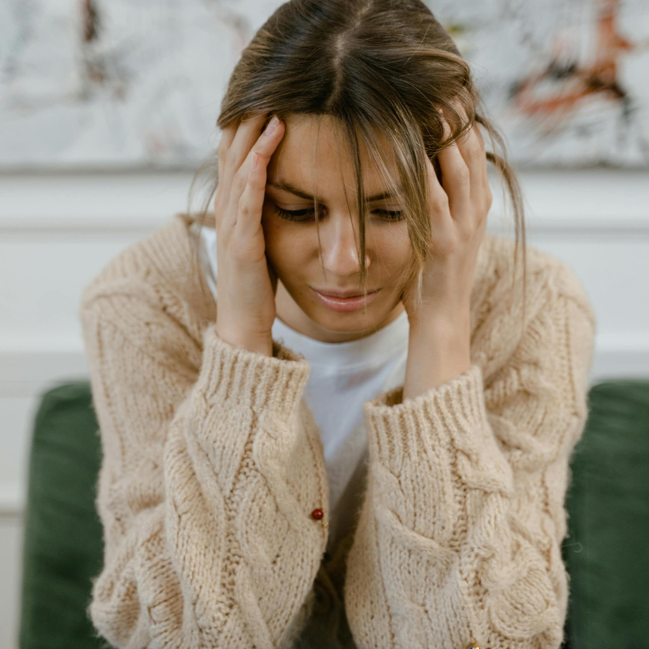 Distressed woman holds her head in her hands