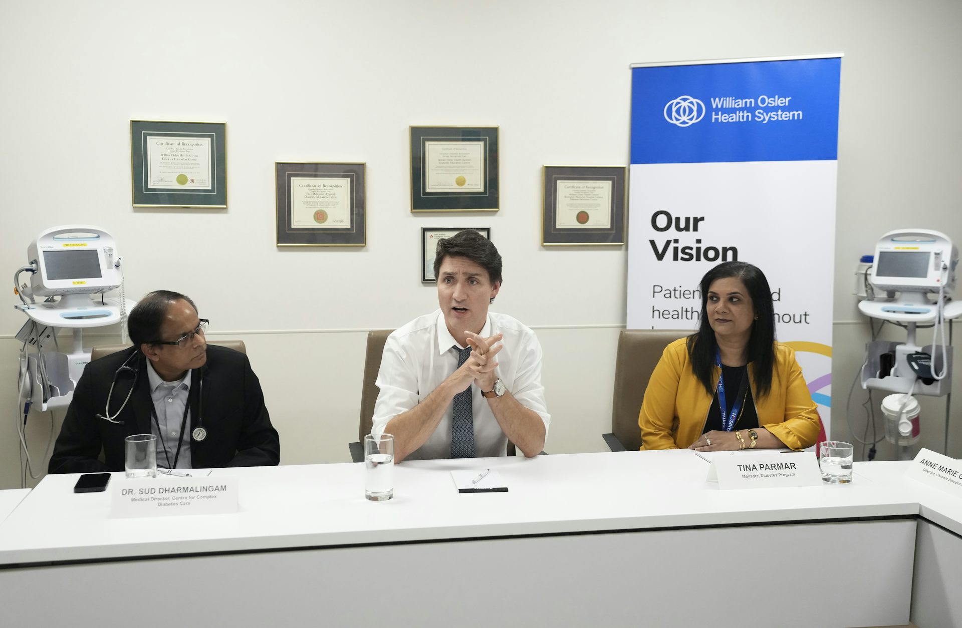 Prime Minister Justin Trudeau and two others sitting at a table