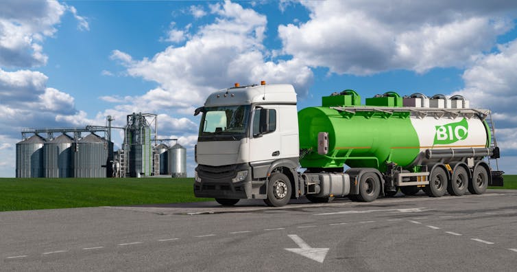 A truck with the word Bio on its side drives past storage tanks