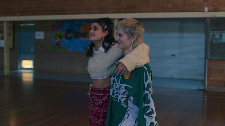 Two girls walk through the gym.