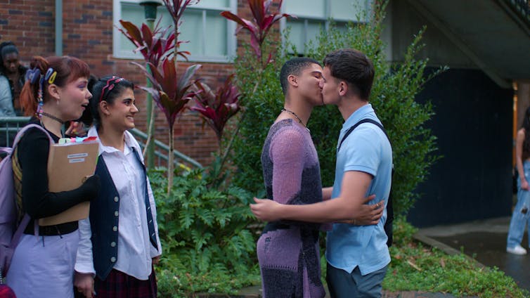 Two boys kiss.