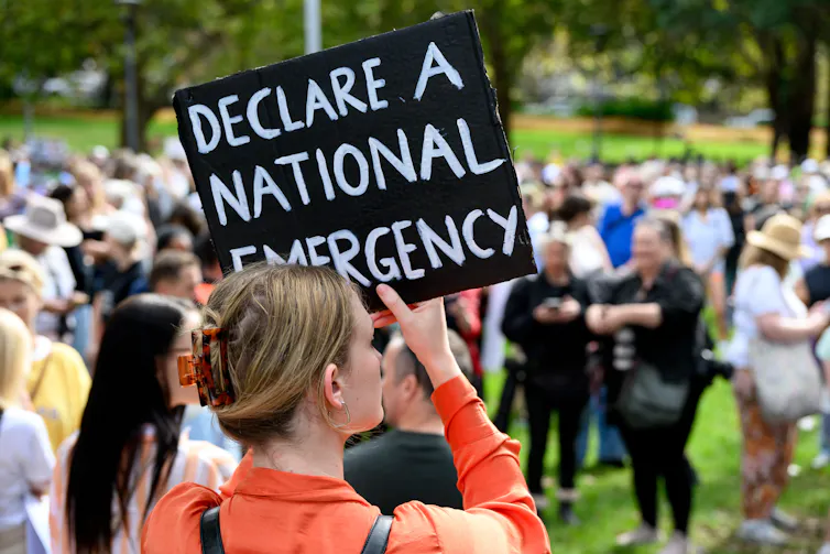 A woman holds up placard during a rally to a call for action to end violence against women in Sydney.