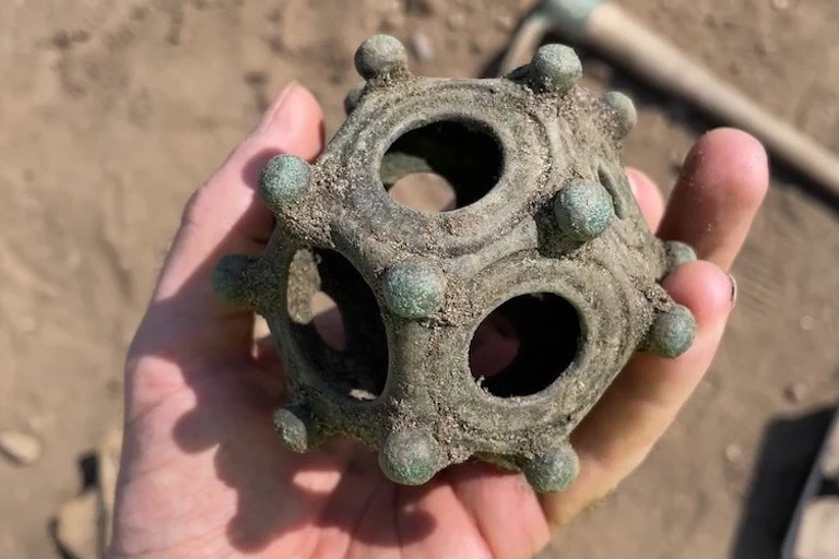 The many sided dodecahedron held in someone's hand.