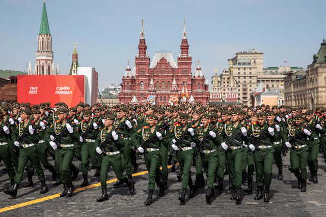 Soldiers in green, with Red Square buildings in background.