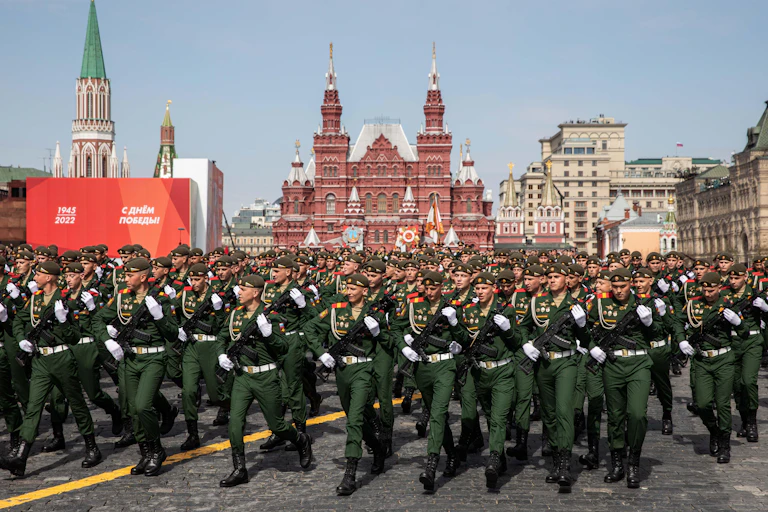 Soldiers in green, with Red Square buildings in background.