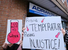 A group of people hold up signs.