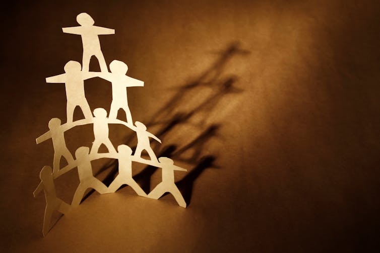 A paper cut-out of a human pyramid