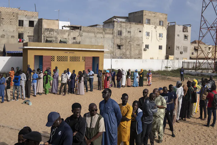 Des Sénégalais et des Sénégalaises font la file pour voter à Dakar