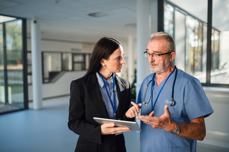 Hospital administrator talking to hospital doctor