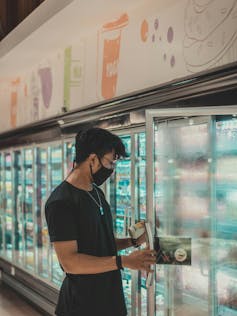 A man looks at the label of a drink