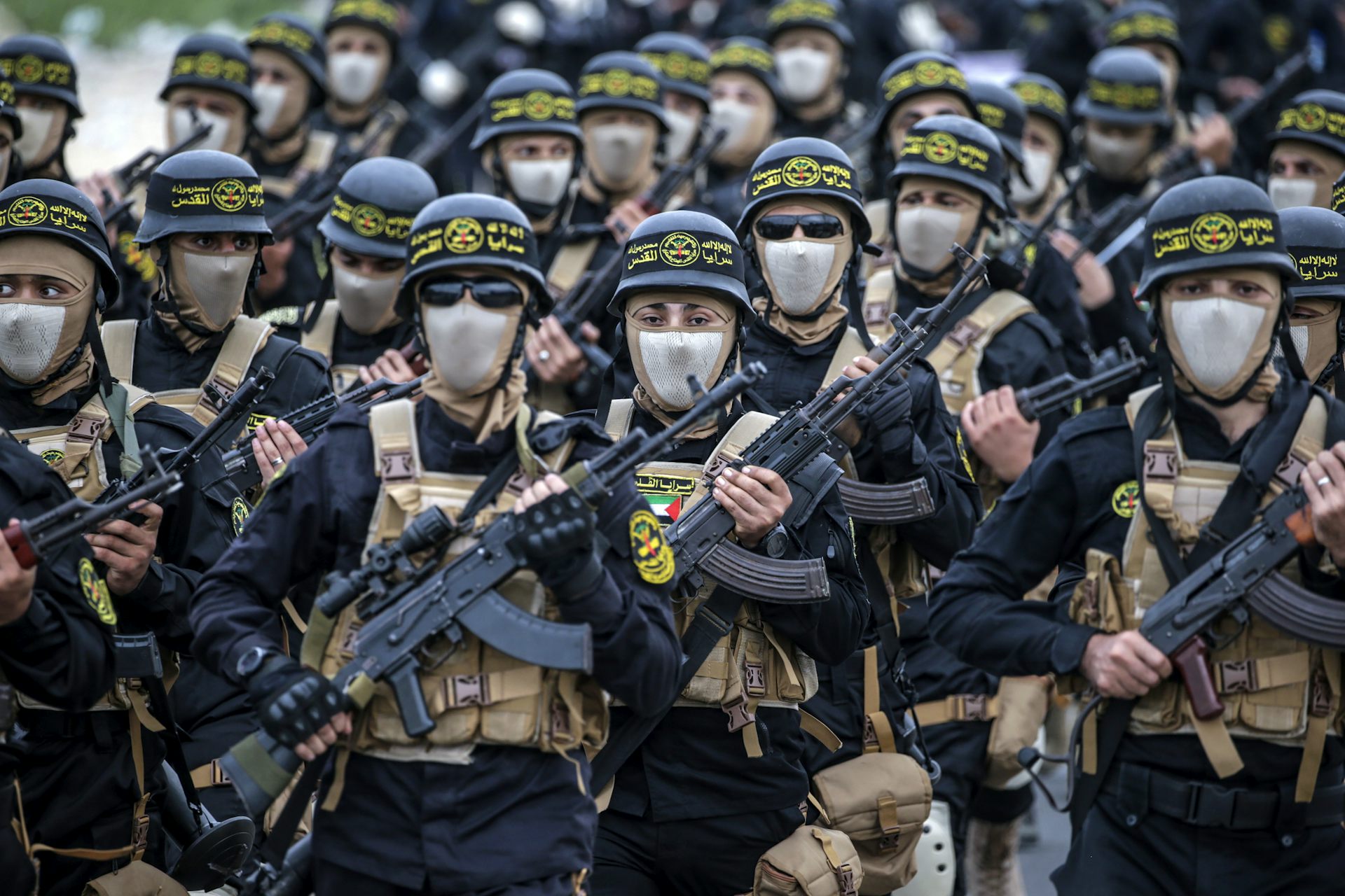 Armed fighters dressed in combat clothing on a march.