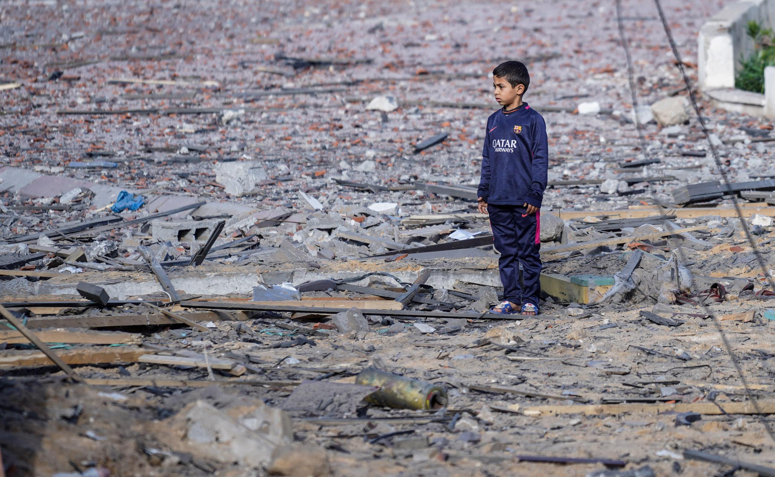 A child standing alone surrounded by rubbleA child seen standing alone surrounded by rubble.