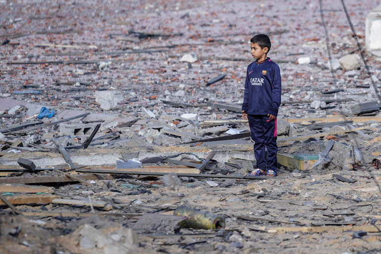 A child standing alone surrounded by rubbleA child seen standing alone surrounded by rubble.